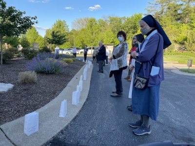 Sisters stand by luminaries as names of deceased are called